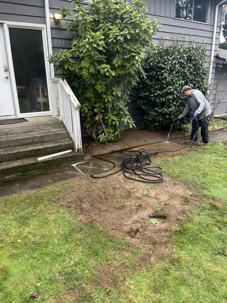 Man cleaning yard with pressure washer