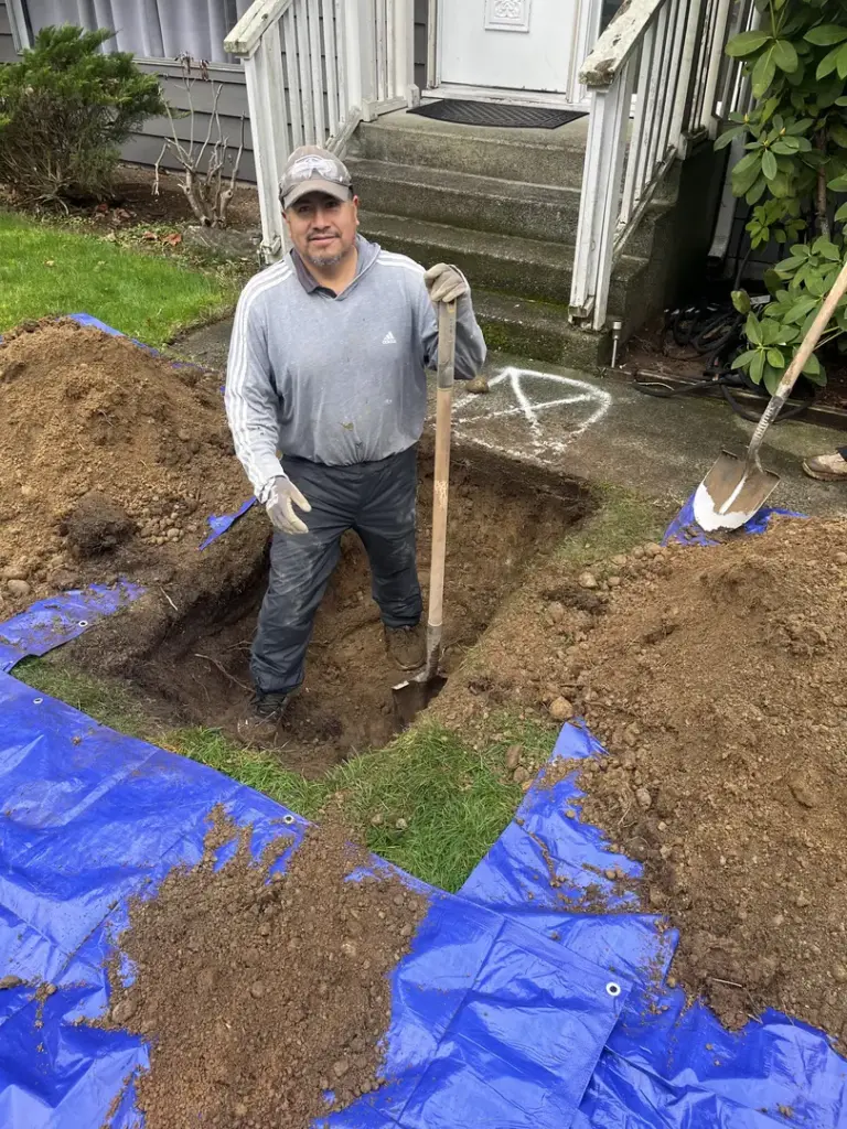 Man digging a trench in yard