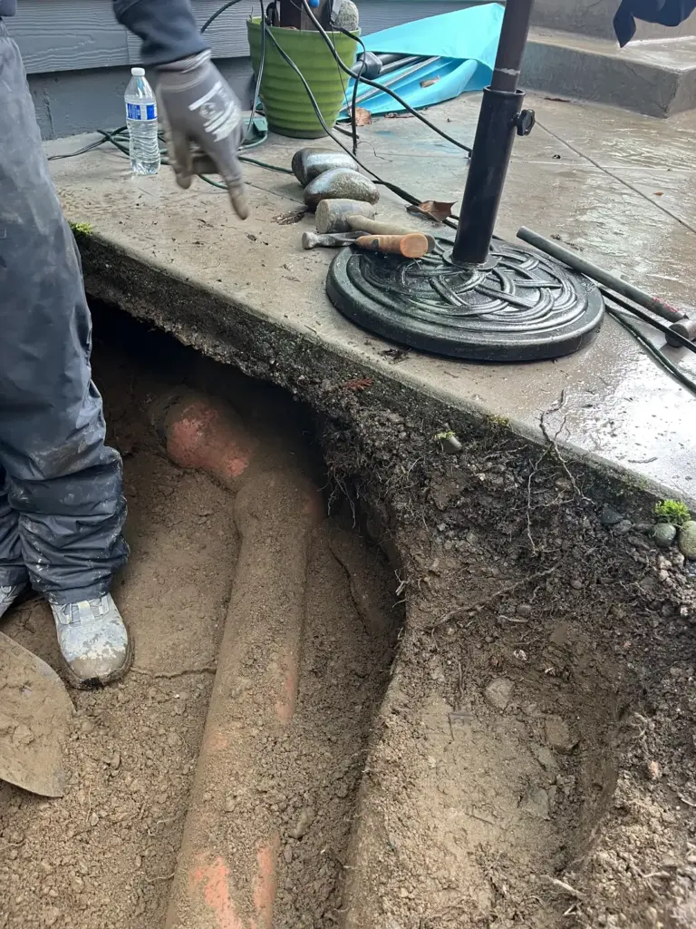 Excavated area revealing sewer pipe