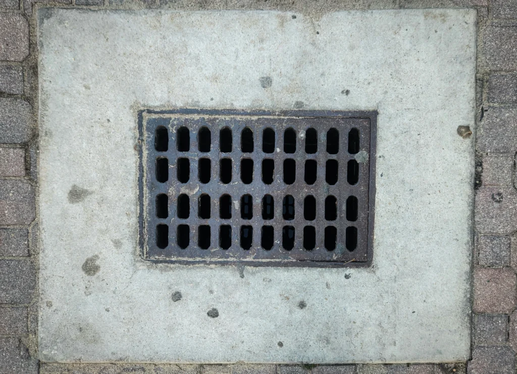 Metal drain cover on concrete surface.